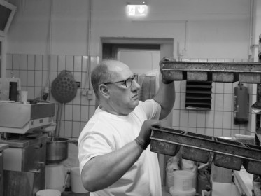 <span style='font-size:0.75em'><strong>Arbeit mit Teig</strong> Der Bäcker holt sich Formen für Kasternbrote. ©Ernst Wilhelm Grüter</span>