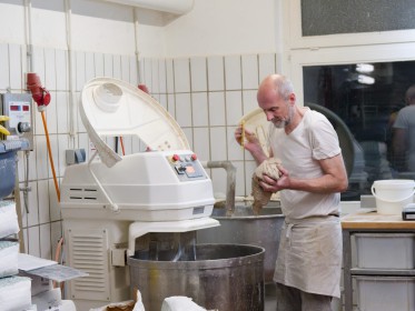 <span style='font-size:0.75em'><strong>Arbeiten mit Teig</strong> Der Rührmaschine wird eine größere Portion Teig entnommen. ©Ernst Wilhelm Grüter</span>