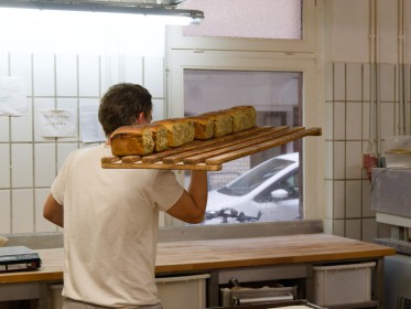 <span style='font-size:0.75em'><strong>Erweiterung</strong> Ein Regalbrett frischer Brote wird in das Ladengeschäft gebracht. ©Ernst Wilhelm Grüter</span>